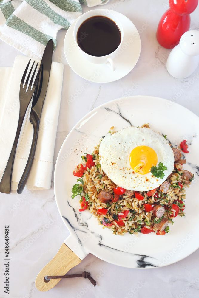 Spicy roast rice with red cherry tomatoes, sausages, fried eggs and cup of coffee for breakfast Spicy roast rice with red cherry tomatoes, sausages, fried eggs and cup of coffee for breakfast