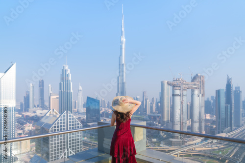 Girl in red dress looking at the city of Dubai