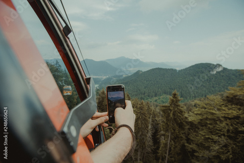 photographer taking photos in the mountains with mobile