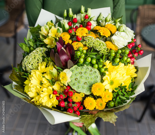 Beautiful flowers in hands. 8 March woman day. Alstromeriya, lotus, hypericum, eustoma, celosia. photo