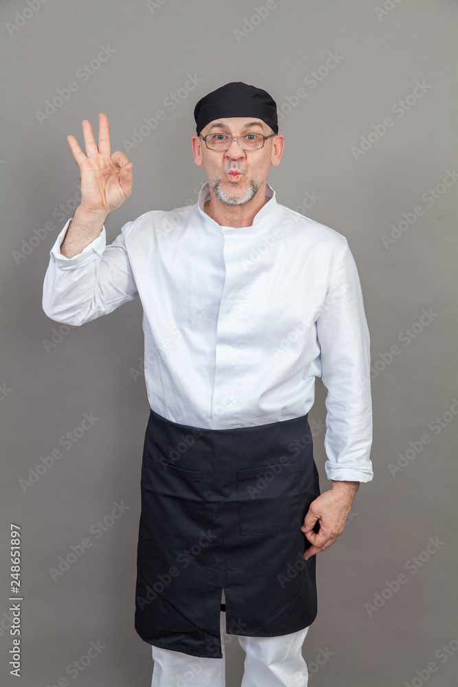 Fototapeta premium Elderly chef on grey background, isolated, concept