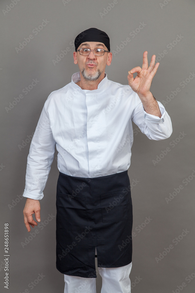 Fototapeta premium Elderly chef on grey background, isolated, concept