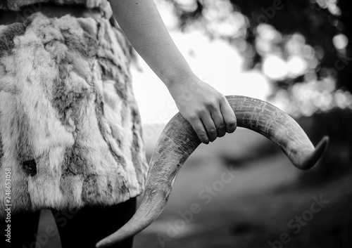 Mujer sujetando cuerno de toro con su mano