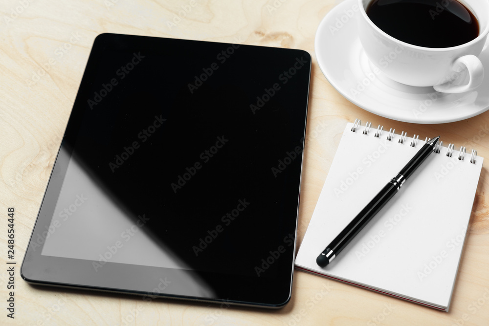 Digital tablet computer and cup of coffee on wooden desk. Digital tablet computer and cup of coffee on wooden desk.