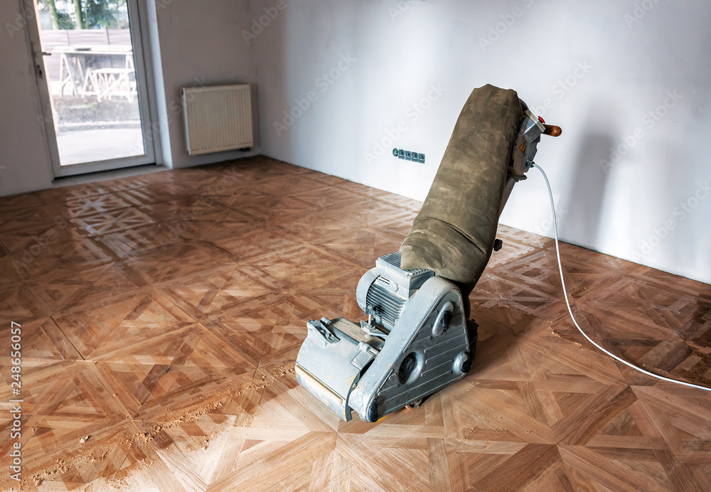 Sanding hardwood floor with the grinding machine. - obrazy, fototapety, plakaty 