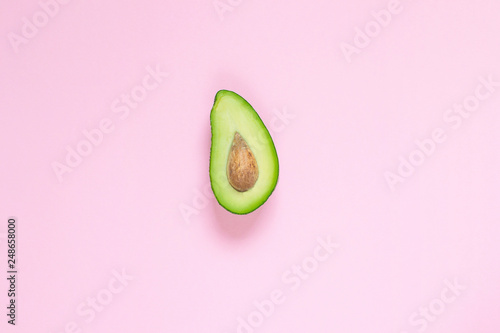 Avocado on pastel pink background, top view, copy space, healthy food concept