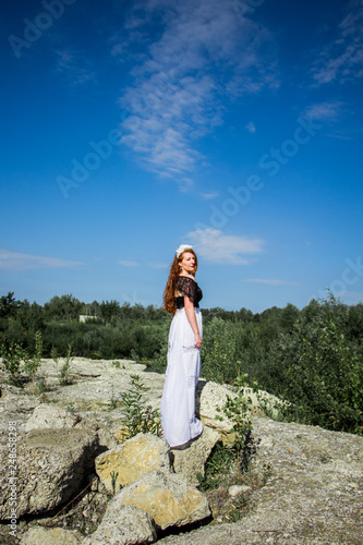 Young beautiful redhead woman on the stone