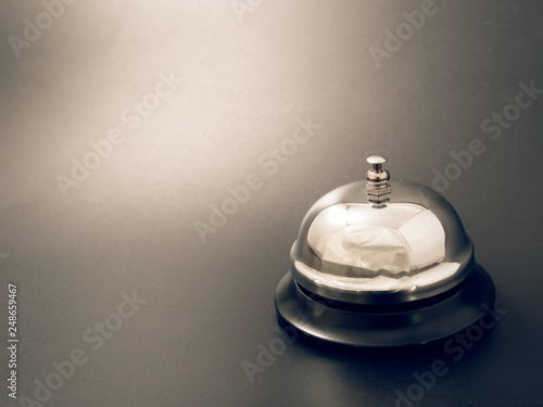 bell at the reception desk made of metal on a black background.