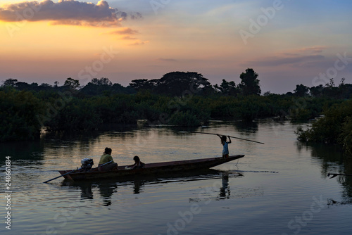 Laotian woman with two children heading home on the boat on Mekong River  at sunset   4000 islands  Don Det  Laos