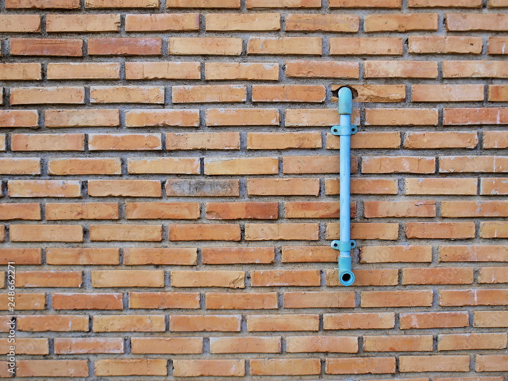 Red brick wall with pvc pipe With copy space. Selective focus Red brick wall with pvc pipe With copy space. Selective focus