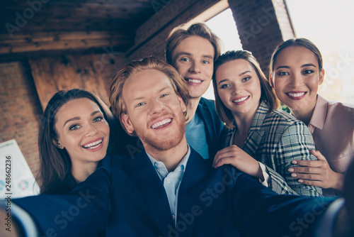 Self-portrait of nice adorable chic beautiful attractive handsome stylish elegant multinational company cheerful positive staff hugging support at modern industrial loft interior work place station