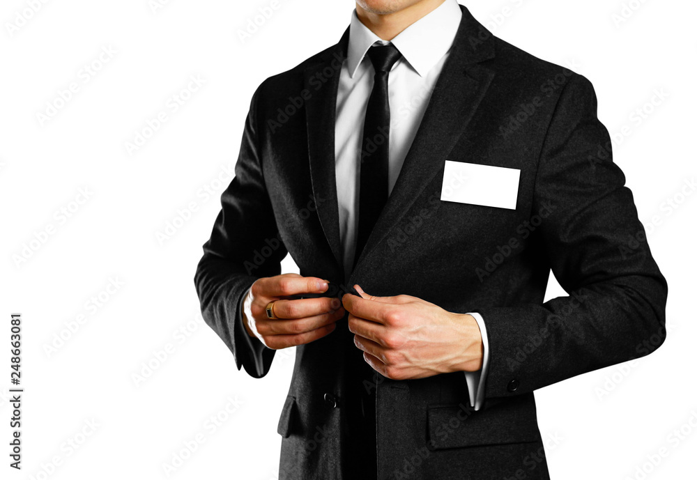 Businessman in a black suit, white shirt and tie. Studio shooting. With a badge. Isolated on white background Businessman in a black suit, white shirt and tie. Studio shooting. With a badge. Isolated on white background