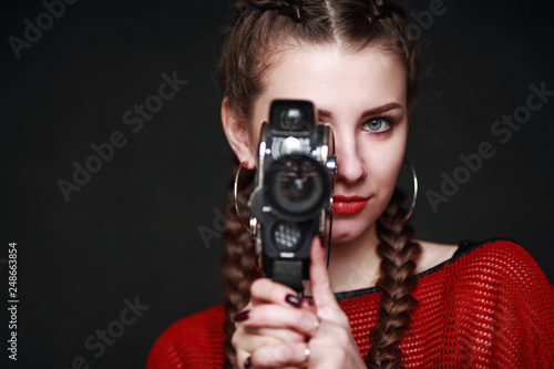 beautiful woman with a retro camera on a black background