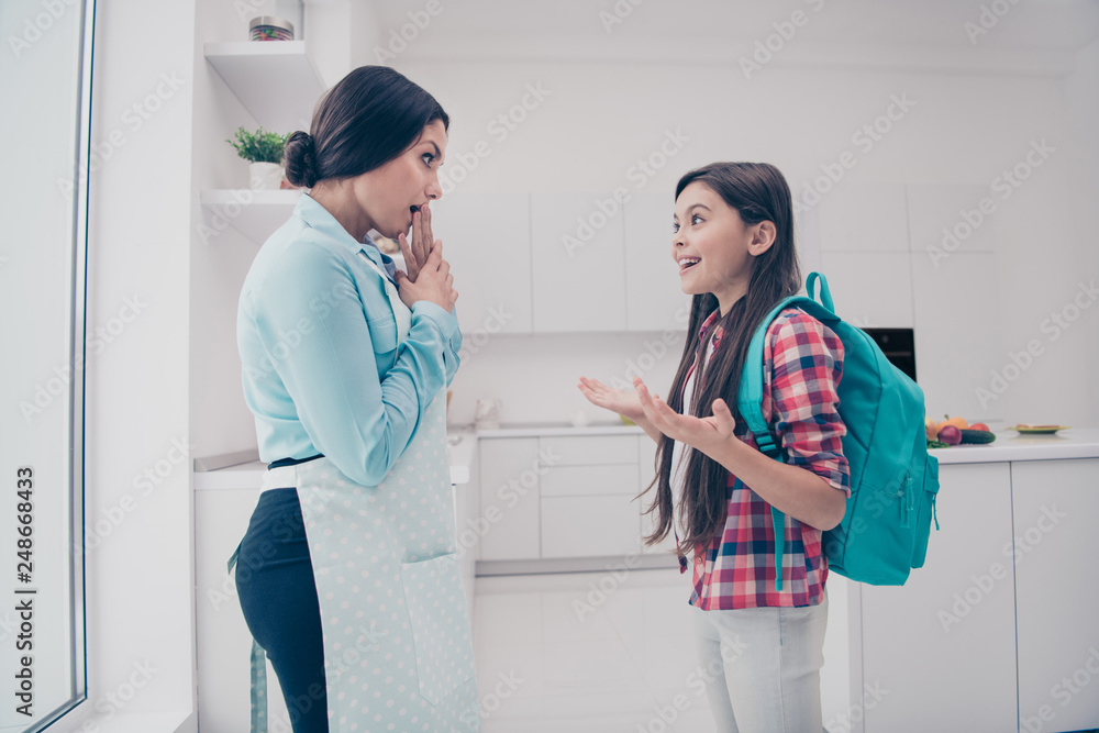 Fototapeta premium Portrait of two nice-looking cute lovely sweet attractive cheerful cheery positive people mature mommy telling funny stories in light white kitchen interior indoors