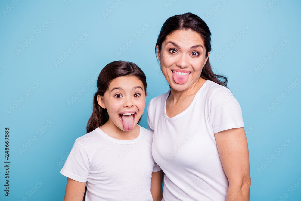 Naklejka premium Close up photo beautiful two people brown haired mom little daughter friends hipsters silly mouth opened tongue out fooling around playing wear white t-shirts isolated bright blue background