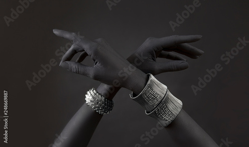 Black woman's hands with many different Silver jewelry. Oriental Bracelets on a black hand.