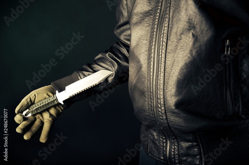 Dangerous criminal hold knife in hand.Large sharp weapon ready for robbery or to commit a homicide.Assassin man.