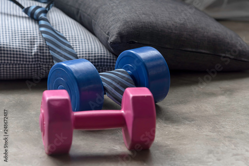 Two dumbbell blue and ping,necktie put on the floor.