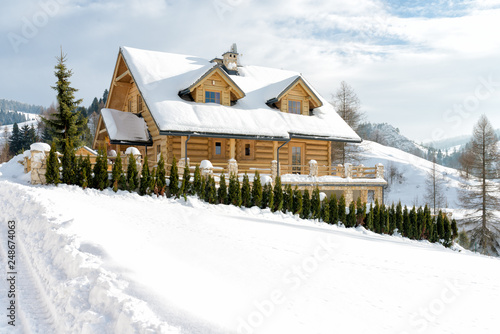 Traditional wooden mountain house built from wood logs on winter sunny day, Pieniny Mountains, Jaworki, Poland - typical farmhouse for this mountainous region photo