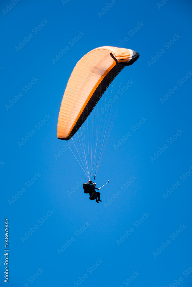 Paraglider Instructor Flying with Customer in Blue Summer Sky Paraglider Instructor Flying with Customer in Blue Summer Sky