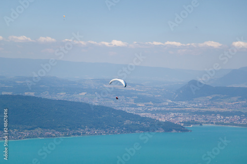 Paragliders Flying over Annecy Lake and Mountain Landscape in Blue Sky