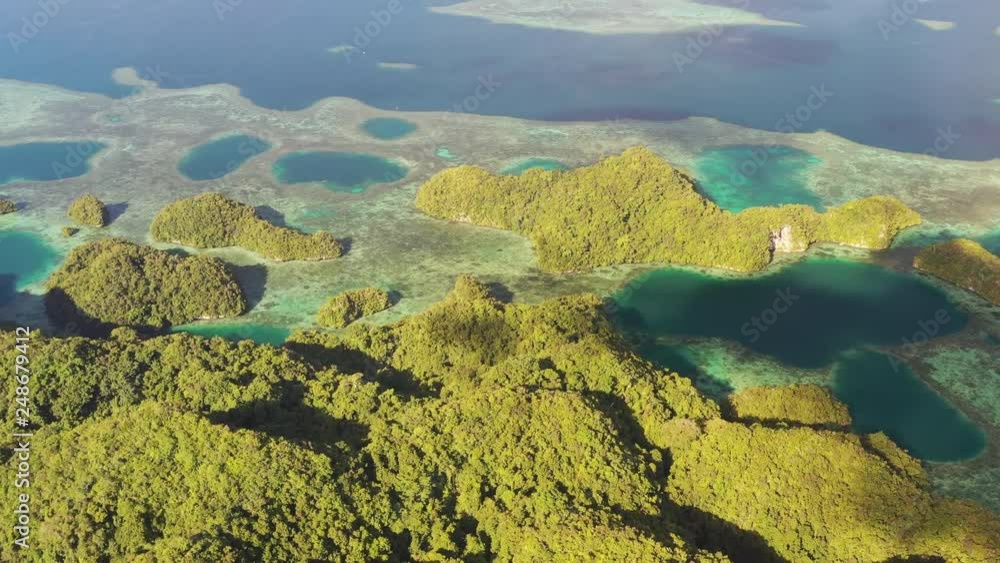 Aerial view of Koror island area during golden hour, lush islands and blue lagoons, azure crystal clear water of western Pacific Ocean - landscape panorama of Micronesia from above, Palau Aerial view of Koror island area during golden hour, lush islands and blue lagoons, azure crystal clear water of western Pacific Ocean - landscape panorama of Micronesia from above, Palau