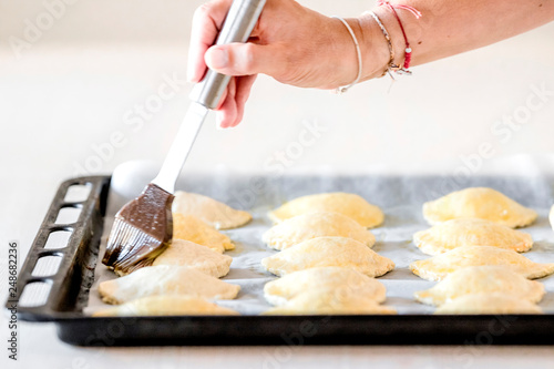 Preparar las empanadas con la mano pintando de huevo antes de hornear photo