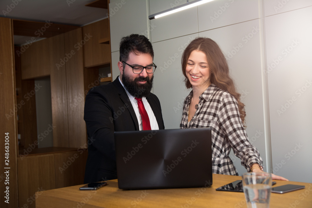 Business man shows program on his laptop to a beautiful woman Business man shows program on his laptop to a beautiful woman
