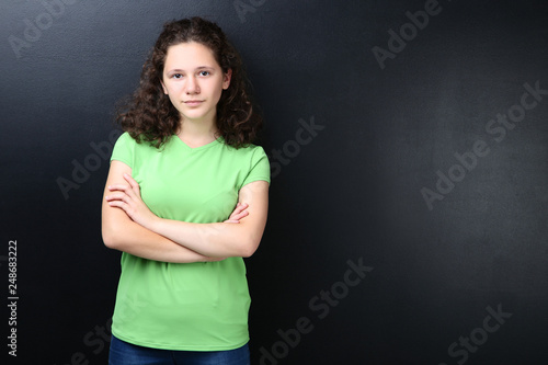 Beautiful young girl on blackboard background