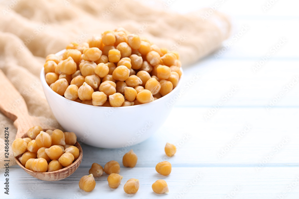 Chickpeas in bowl and spoon on wooden table Chickpeas in bowl and spoon on wooden table