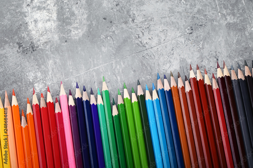 Colored pencils on grey wooden table Colored pencils on grey wooden table