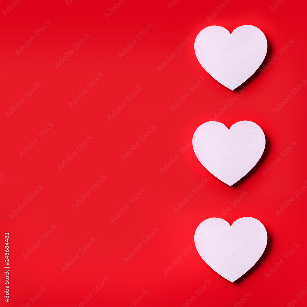 White heart cutted from paper over red background with copy space. Top view. Valentine's Day. Love, date, romantic concept. Square crop