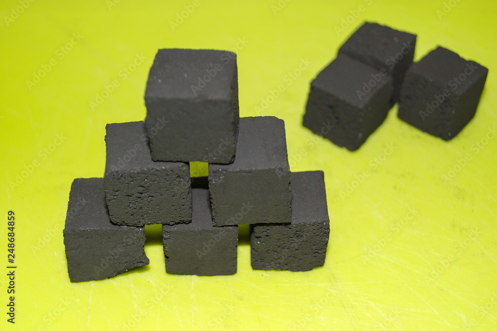 coconut coal cubes on bright green background coconut coal cubes on bright green background