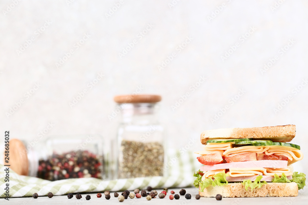Sandwich with ham, vegetables and black pepper on grey background