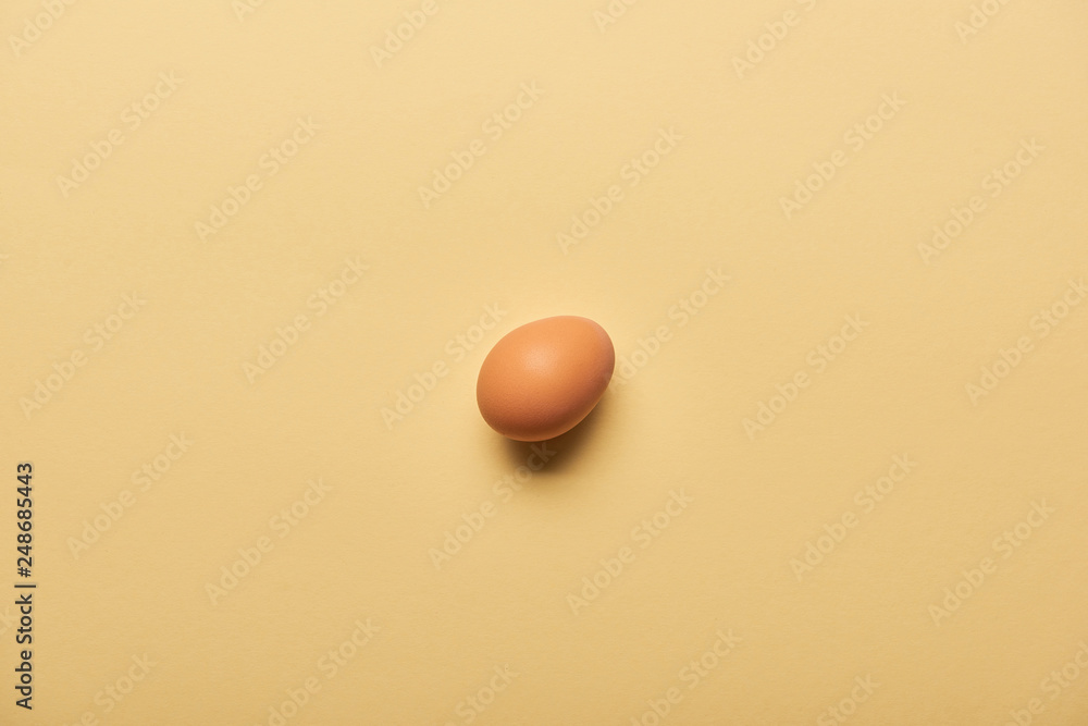 top view of fresh egg on yellow background top view of fresh egg on yellow background