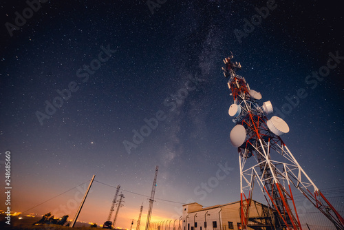 From below tall modern radio tower located against majestic starry sky at wonderful night