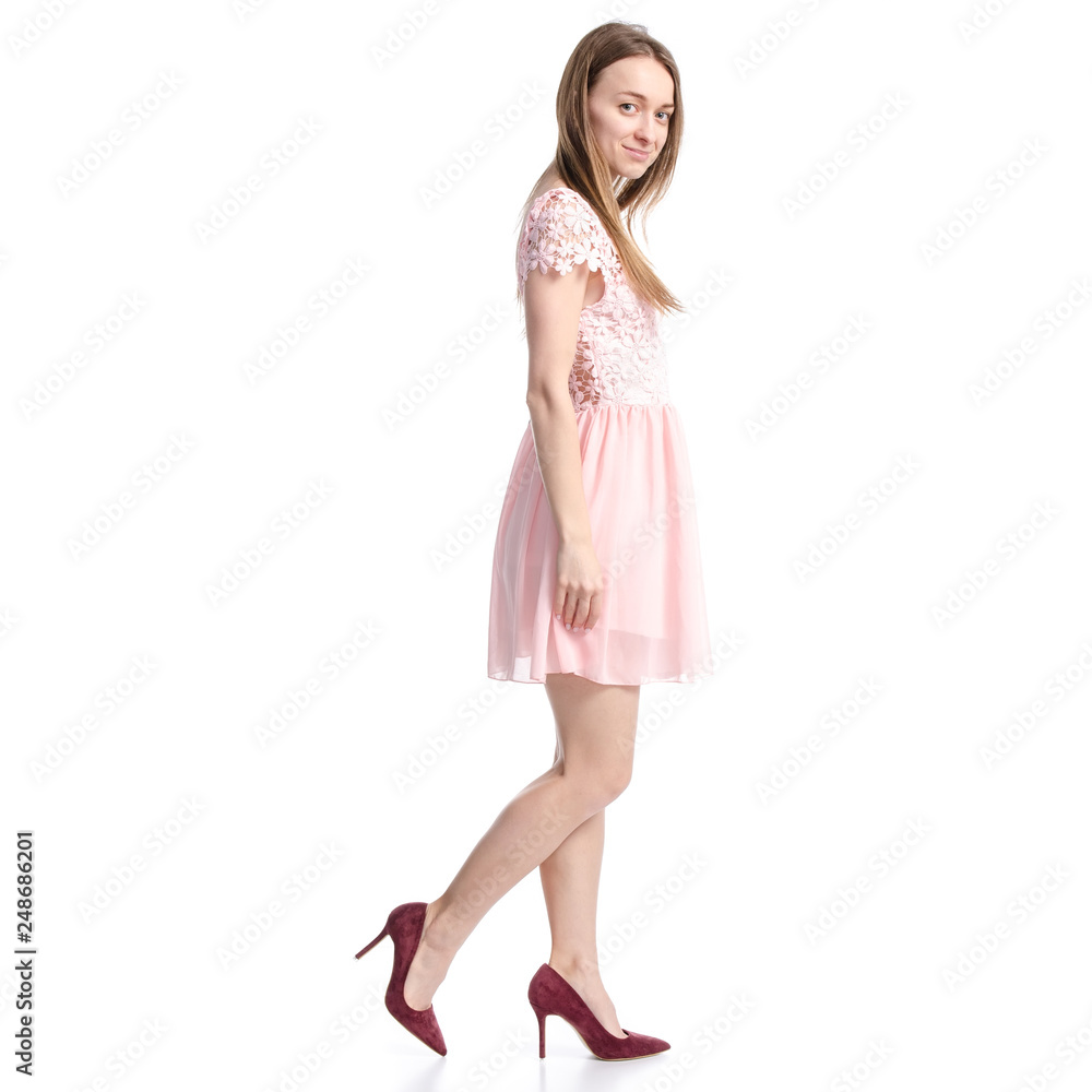 Woman in pink dress and red high heel shoes goes on white background isolation