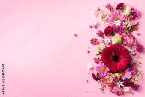 Fototapeta Naklejka Na Ścianę i Meble -  Spring composition of pink flowers on punchy pastel background with copy space. Creative layout. Flat lay. Top view. Summer minimal concept.