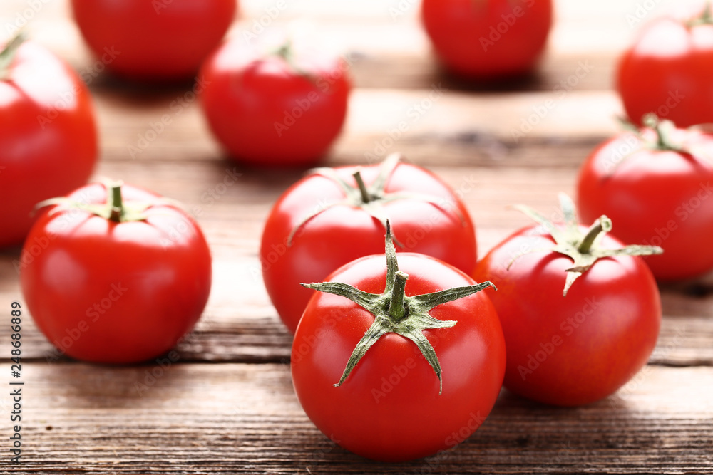Fresh and ripe tomatoes on brown wooden table Fresh and ripe tomatoes on brown wooden table