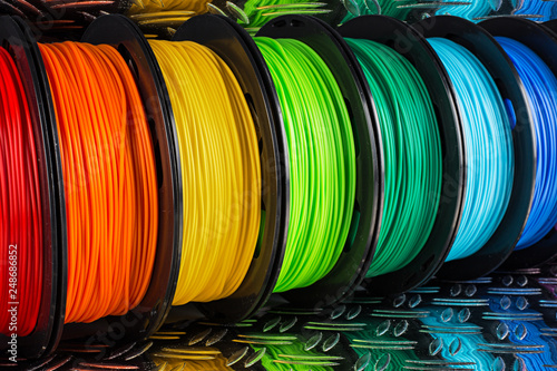 colorful bright row of spool 3d printer filament black metal background