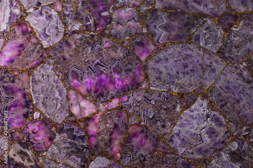 Natural purple amethyst, light highlights how translucent parts of the stone and it becomes pink