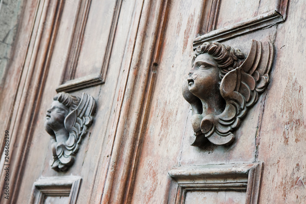 Sculpture of an angel on a wooden door in Italy
