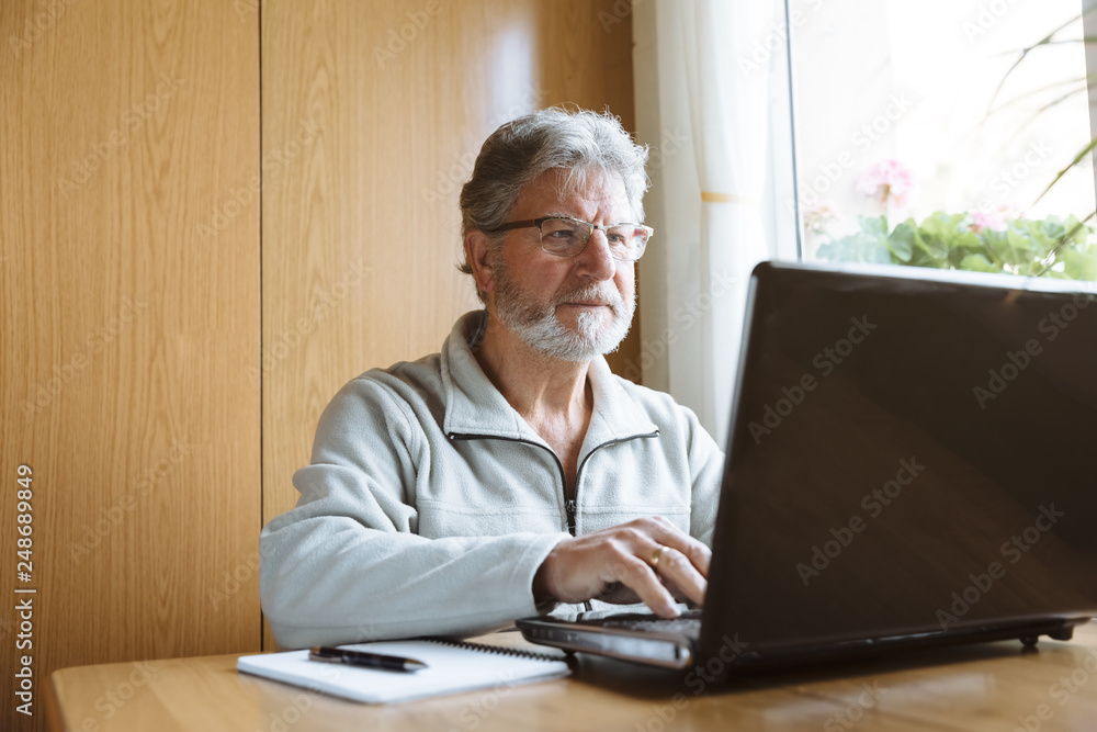 Senior man working with his laptop at home Senior man working with his laptop at home