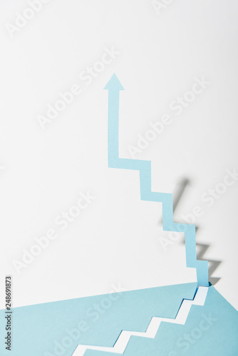 paper arrow upward on white and blue background