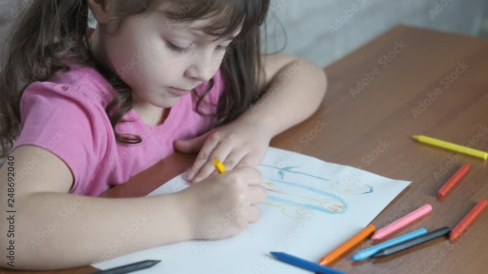 Happy little girl draws with crayons. Happy little girl draws with crayons.