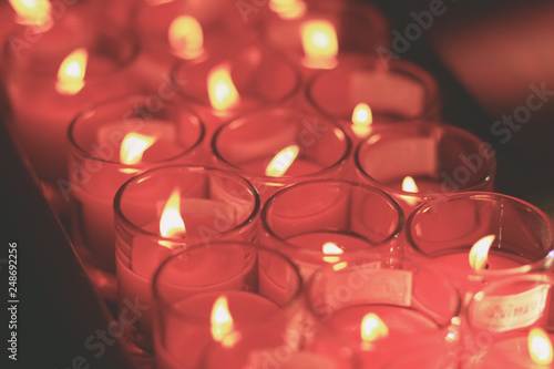 Beautiful red-orange light of many worship candles