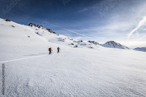 Skitour im Winter in den Alpen unter blauem Himmel