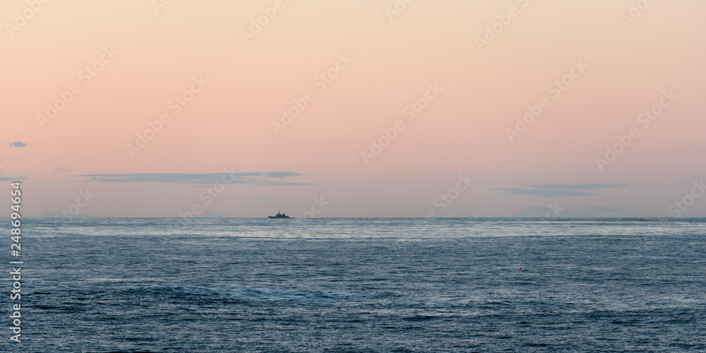 Blaues Meer vor orangenem Himmel 