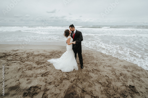 The bride and groom are walking along the beach. Panoramic view.