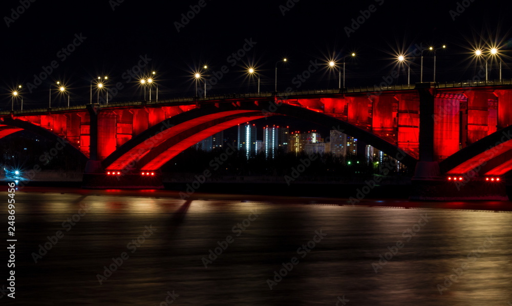 Obraz premium Winter night view of the city of Krasnoyarsk. The Communal bridge through the Yenisei River
